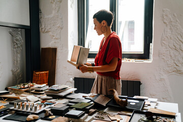 White female interior designer working at her workshop - obrazy, fototapety, plakaty