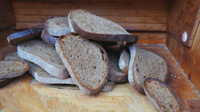 There are many pieces of stale bread in the breadbasket. Food losses and food waste. Spoiled extra bread