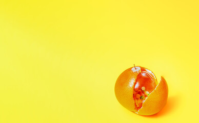 Family miracle, a transparent Christmas tree decoration is inside a grapefruit, the concept of a New Year's miracle and decoration, an unusual holiday decoration for Christmas, an image for a banner