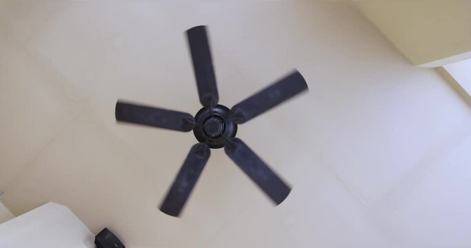 White ceiling fan spinning. Asian style. Thai style. Cooling Indian Style ventilator. Blowing fresh cool Air Condition fan spinning and rotating at very high speed. Slow rotation fan. Eco friendly