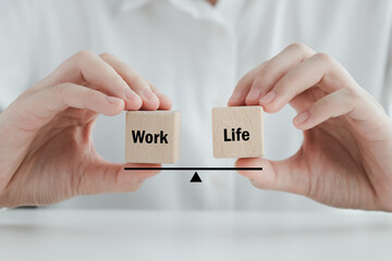 Work Life balance on wooden block. Manage and prioritizes the demands of career and the demands of...