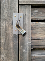 Closeup of a weathered padlock on an old wooden door