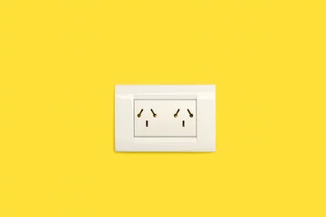 Foto op Canvas Toma de corriente en la pared amarilla lisa y aislada. Vista de frente y de cerca. Copy space. Concepto: Suministro eléctrico © Mercedes Fittipaldi