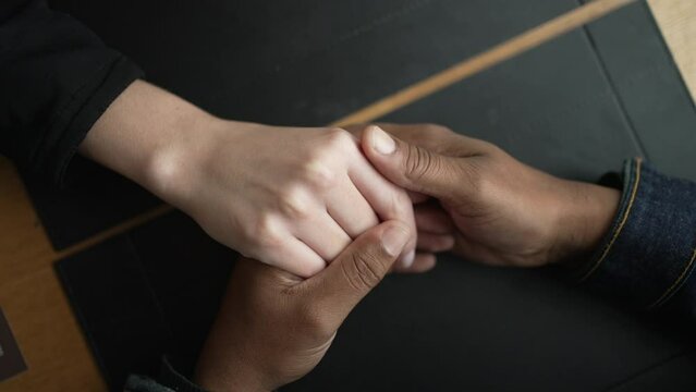Closeup of hands together. Diversity concept of couple in love. Love and affection concept