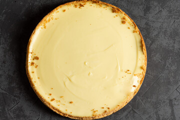 Homemade classic cheesecake on a dark background. Making a delicious cake at home