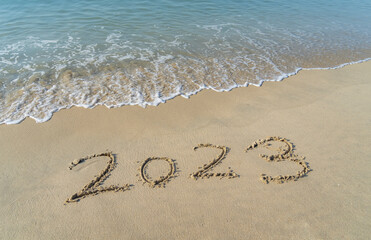 2023 handwritten in sand on a beautiful beach
