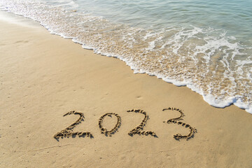 2023 handwritten in sand on a beautiful beach