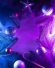 Christmas layout with christmas tree branches, christmas decorations in vibrant neon glow. copy...