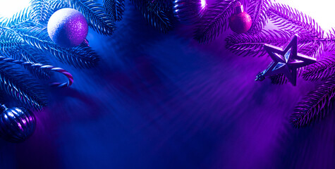 Christmas layout with christmas tree branches, christmas decorations in vibrant neon glow. copy space. top view. flat lay