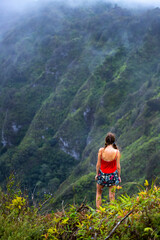 girl in pigtails stands at the top of the kuliouou ridge trail admiring the panorama of oahu,...