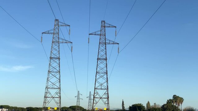 Intermittent functioning of high voltage power lines in Ukraine, transmission electricity pylons against blue sky background, frequent breakdowns of transmission towers, high electrical consumption