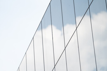 Glass on a tall building reflecting on the clouds