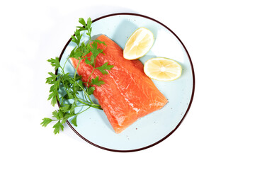 Salmon, fresh raw fish fillets together with parsley and lemon on a plate