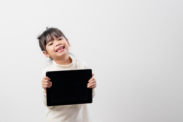 Fototapeta premium Asian little girl holding and using the digital tablet on white studio background, free copy space