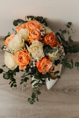 White Heels Filled With Orange Flower Bouquet
Simple white heels with a bouquet of beige, orange roses, and green details laying on the floor