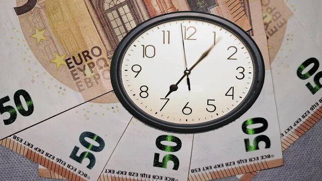 Clock animated icon, with moving arrows simple animation. Euro banknotes, "time is money". Stuck second hand. No people are visible.