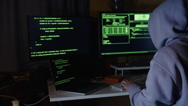 Young hacker, working and hacking with his computers. Attacking systems and danger computering.