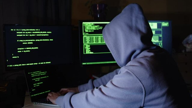 Young hacker, working and hacking with his computers. Attacking systems and danger computering.