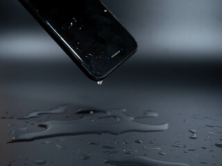 Close-up of an old telephone in water on a black background.