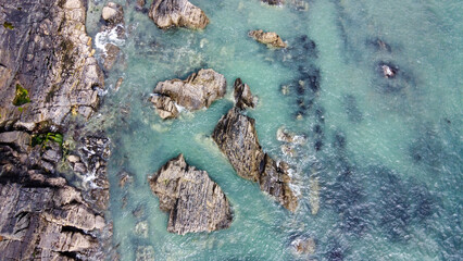 A lot of boulders in the sea. Coastal cliffs of the North Atlantic. Seaside beautiful nature. Dramatic seascape of the north of Europe. Drone photo.