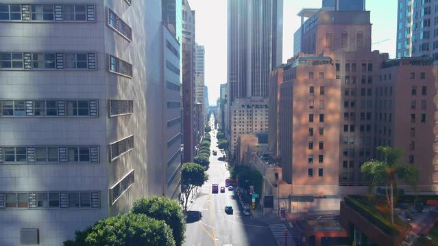 Descending Aerial Footage Along Grand Ave With Skyscrapers And Office Buildings And People Walking And Cars And Trucks Driving On The Street In Los Angeles California USA