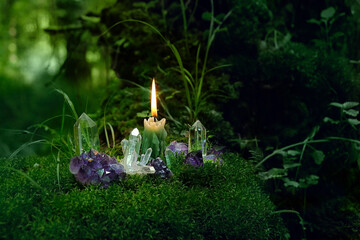 Minerals and candle close up in mysterious forest, dark natural background. Witchcraft, Esoteric...