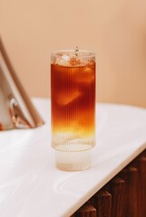 Vertical shot of a cold brew tonic drink in a glass cup.