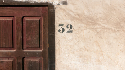 Número 32 en fachada rústica