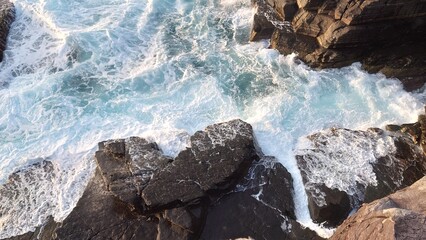荒波が岩にぶつかり白く泡立つ海