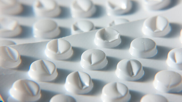Dos embalajes de pl&aacute;stico blanco con compartimentos chafadas y pastillas vac&iacute;os