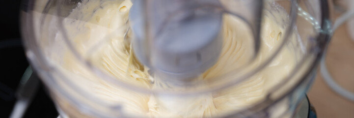 Mixer beats dough or cream for baking closeup