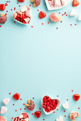 Valentine's Day concept. Top view vertical photo of heart shaped plates with confectionery candies...