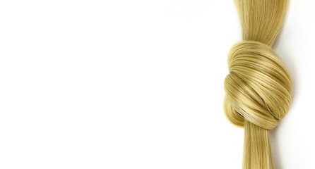 Blonde hair lock tied in knot. Lock of blonde wavy hair on white background, top view.