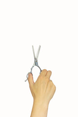 Female hand holding hair accessories Scissors over white background, copy space. Set of hairdresser's tools on white background.