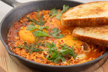 Pan of cooked shakshuka middle eastern dish with bread
