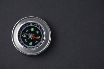 Metallic compass on a black background.