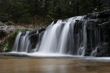 Fototapeta na wymiar Waterfall in the winter forest in Roztocze.