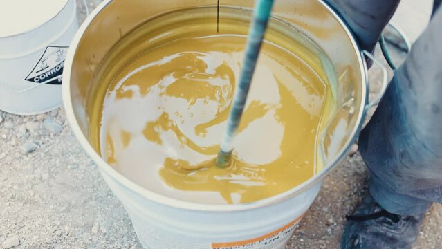 Closeup shot of mixing yellow epoxy for flooring