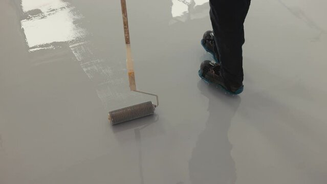 Worker spreading the epoxy on the floor