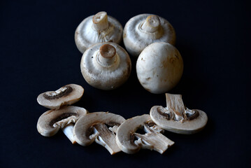 Large white mushrooms of champignons on a black background. Beautiful porcini mushrooms. Champignons close-up.