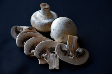 Large white mushrooms of champignons on a black background. Beautiful porcini mushrooms. Champignons close-up.