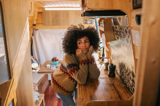 Pensive girl in the kitchen of her camper van