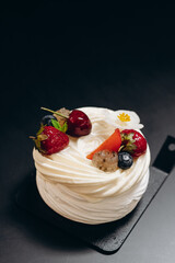 Pavlova dessert made of fresh meringue with cream cheese decorated with berries.
