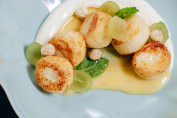 Cheesecakes in sour cream sauce decorated with caramel and grapes.