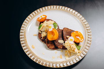 Chocolate pancakes with apricots and almond shavings.