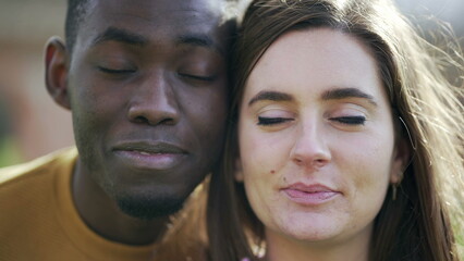 African man and white girl closing eyes together. Interracial couple eyes closed