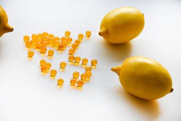 Ripe yellow lemons on a white background. Lemons and medicine in yellow ampoules. Citric acid in...