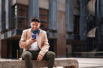 young hispanic man using cellphone outdoors, ethnicity and technology concept