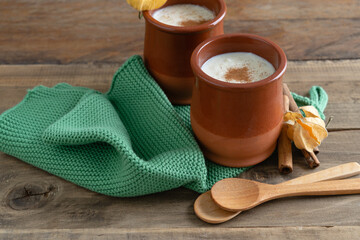 Bowls of rice pudding and cinnamon on a wooden background. Copy space.