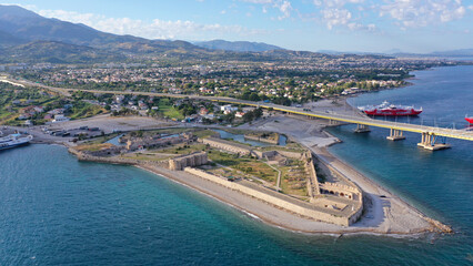 Aerial drone photo of iconic medieval ancient castle of Rio built next to modern cable strait bridge of Harilaos Trikoupis crossing corinthian Gulf, Central Greece